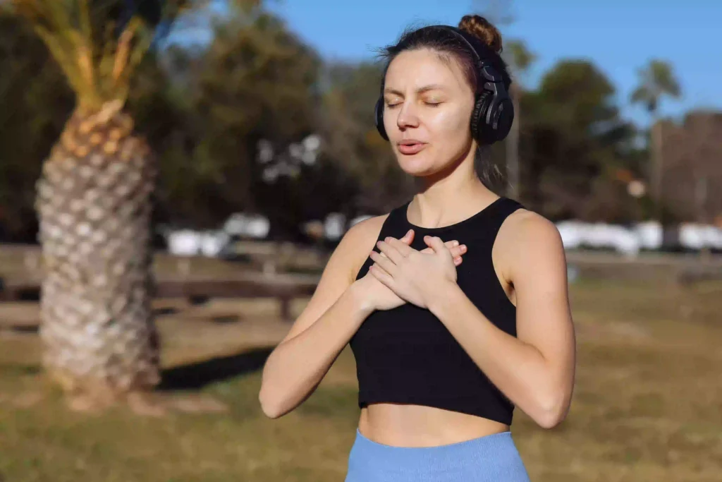 Silent yoga Dubai participant using wireless headphones for meditation and mindfulness