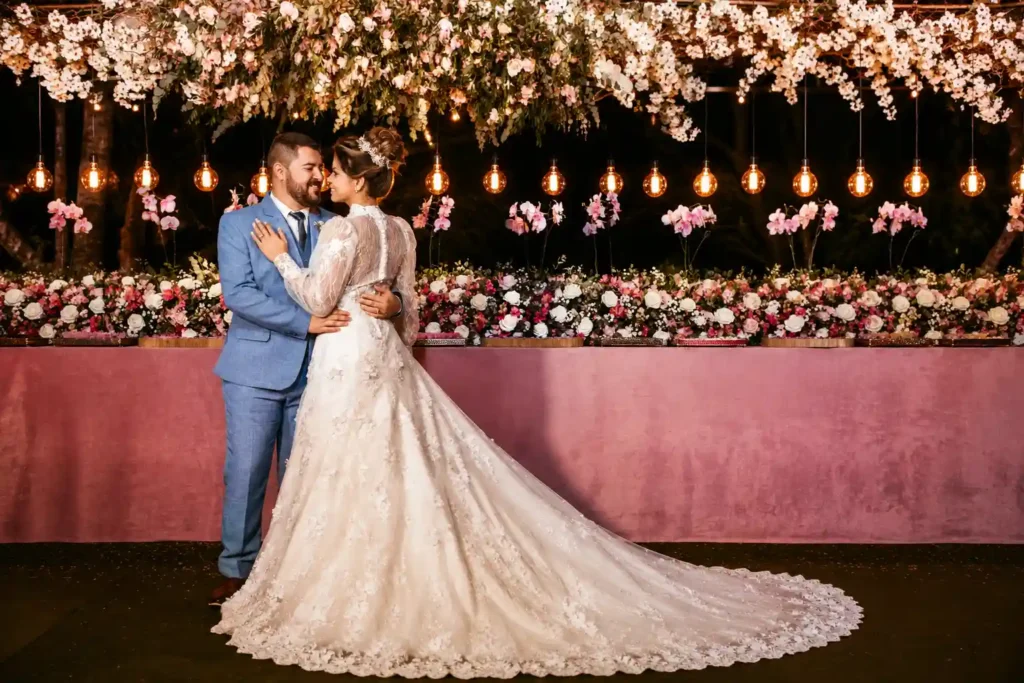 Warm Edison bulb lighting combined with elegant floral decor creates a romantic and unforgettable atmosphere for this luxury wedding reception.