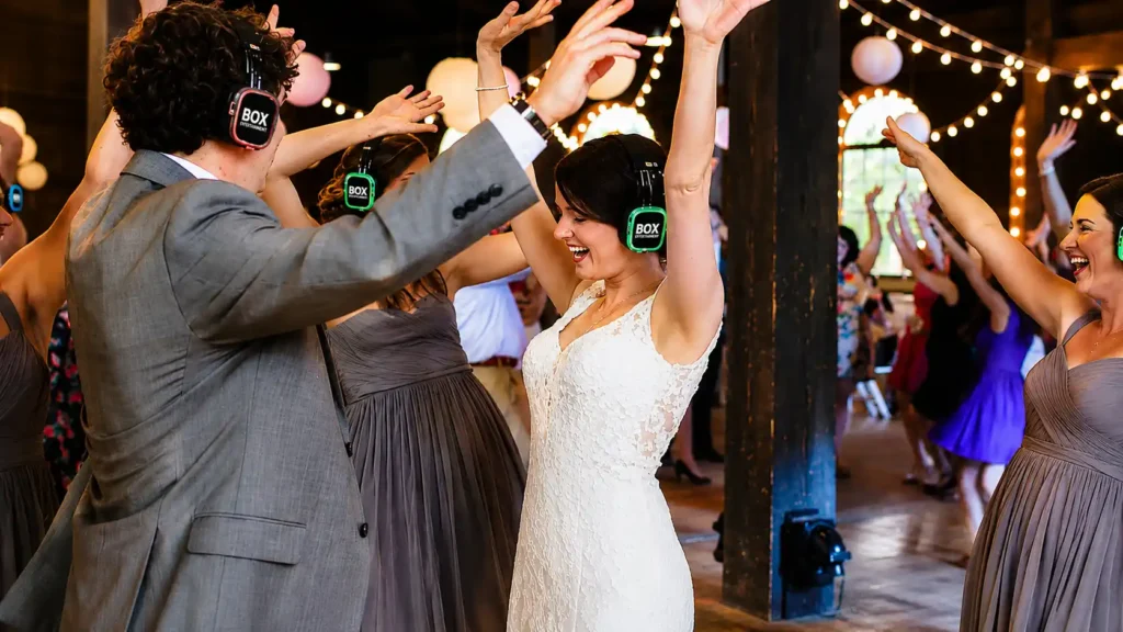 Bride and wedding guests dancing with wireless silent disco headphones at a wedding reception, creating a fun and interactive party atmosphere.