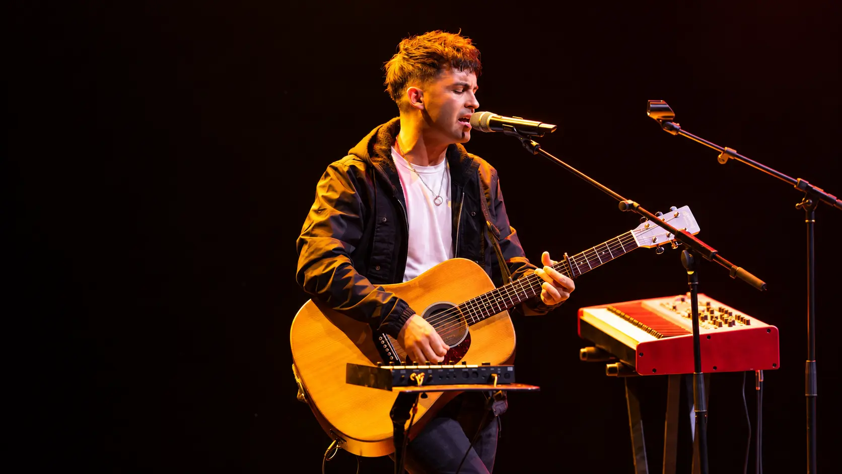 Greg Pearson singing and playing acoustic guitar during a live performance in Dubai, UAE.