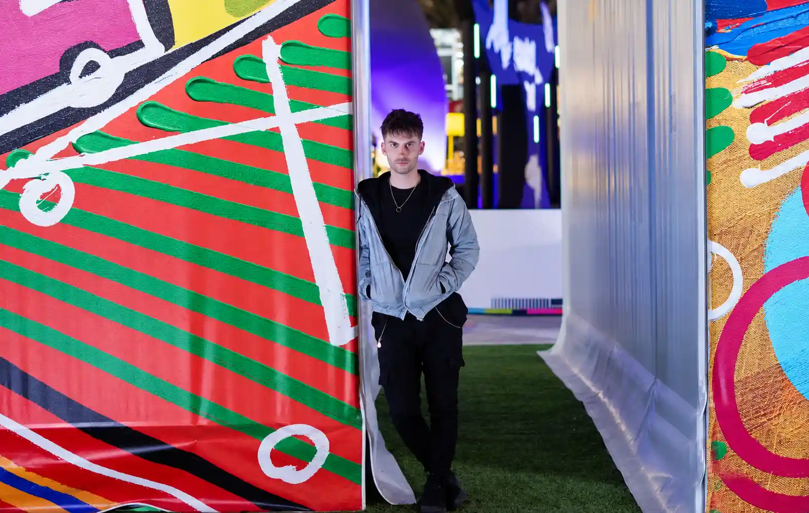 Greg Pearson standing inside a colourful art installation at an event in Dubai, UAE.