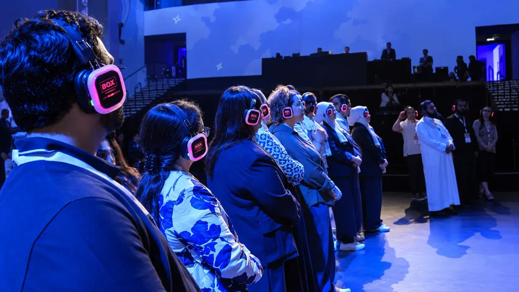 Guests wearing glowing Box Entertainment wireless headsets during an indoor event in Dubai.