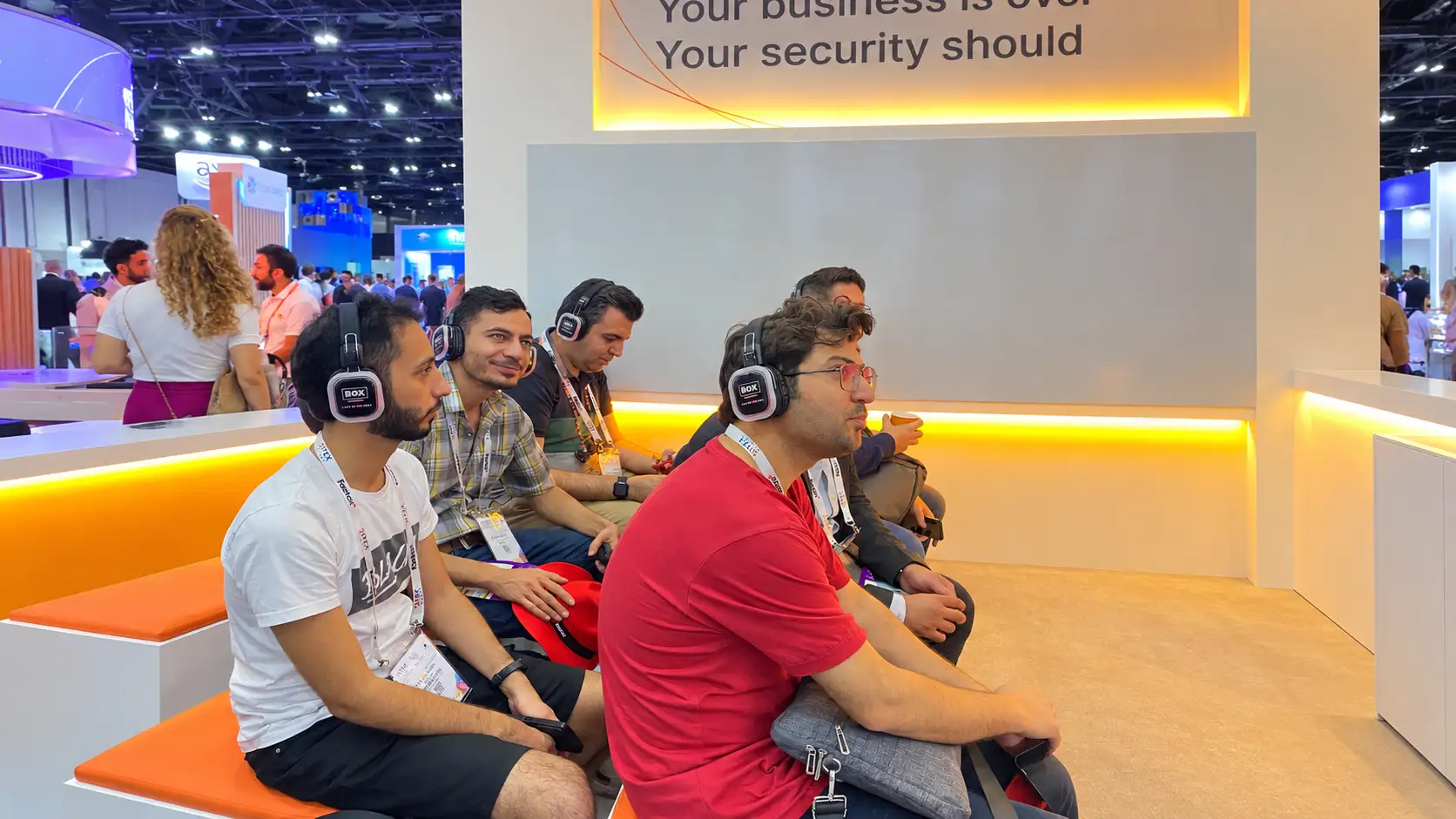 Attendees seated on orange benches wearing BOX Entertainment silent headsets during a GITEX seminar in Dubai.